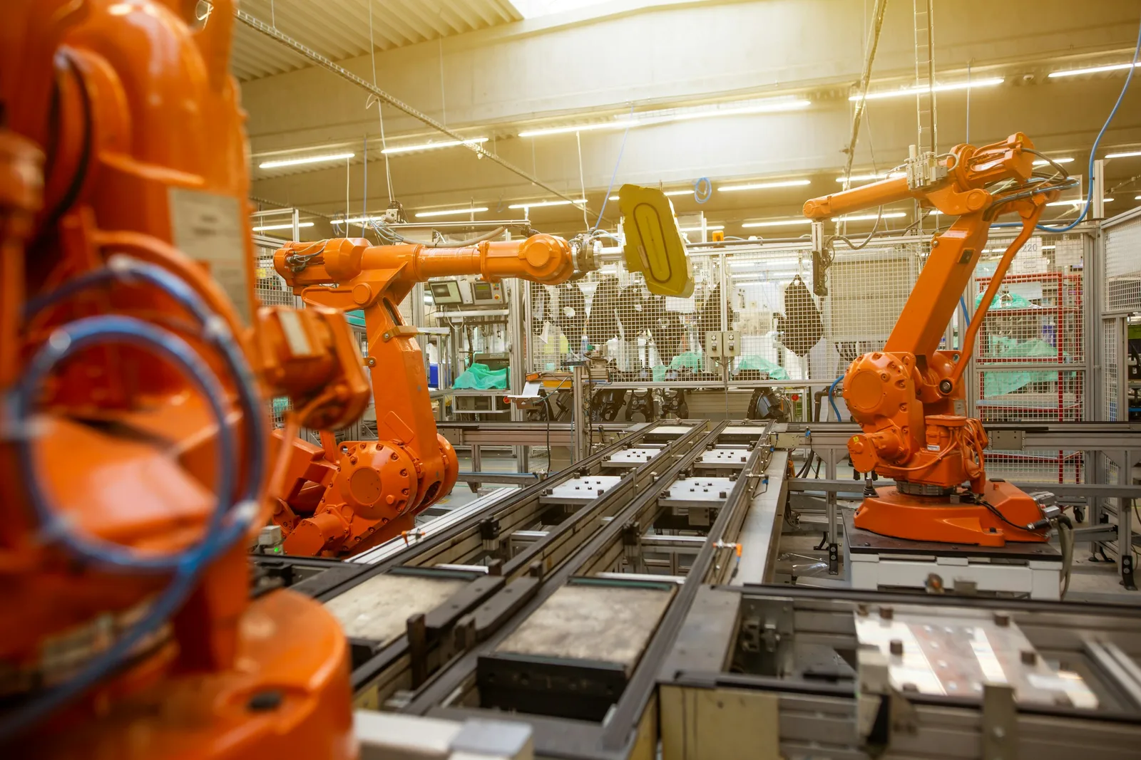 Industrial robot arms and assembly equipment on a large factory floor