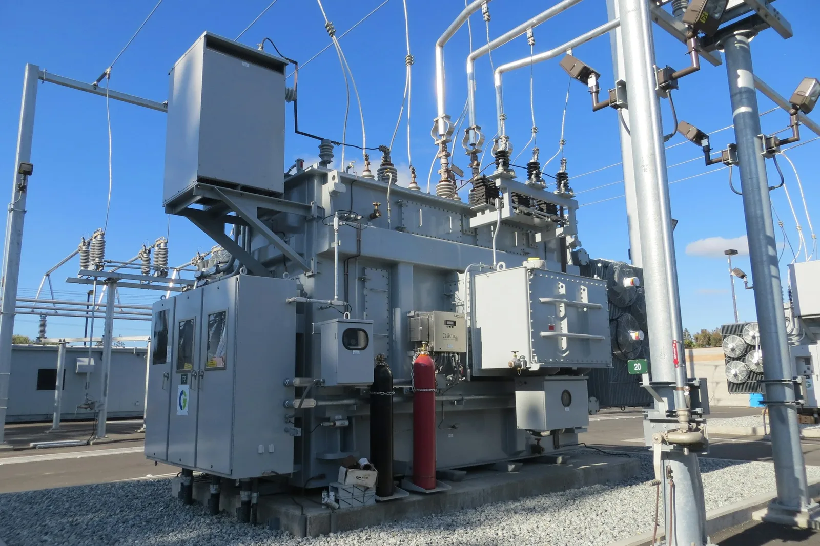 Large power transformer with cooling equipment and insulators at an electrical substation